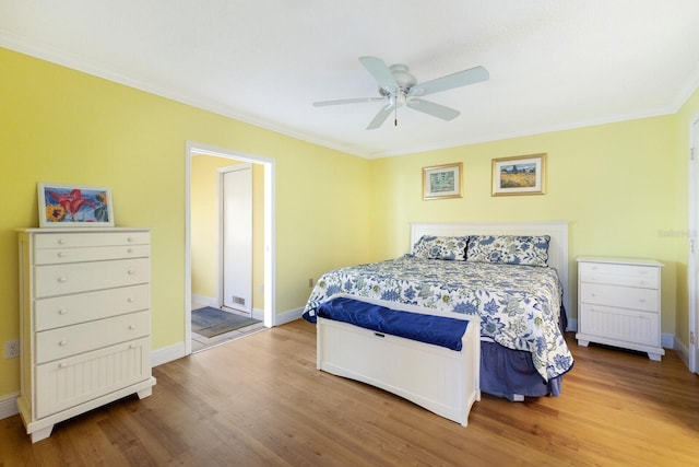 bedroom with crown molding, hardwood / wood-style flooring, and ceiling fan