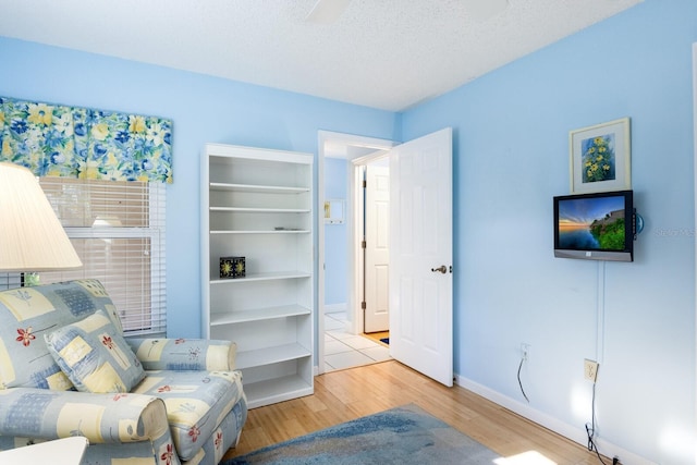 sitting room with light hardwood / wood-style floors and a textured ceiling