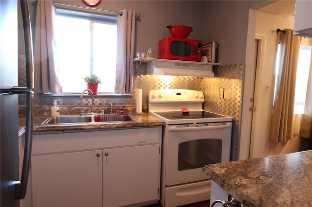 kitchen with sink, range hood, white appliances, decorative backsplash, and white cabinets