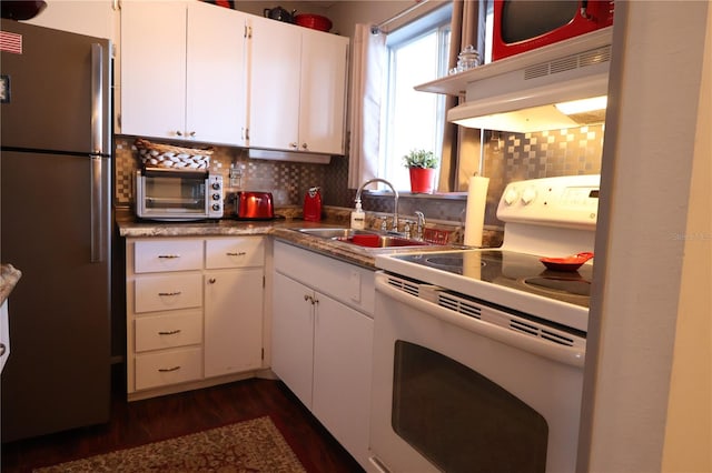 kitchen with backsplash, sink, white electric stove, white cabinets, and stainless steel refrigerator