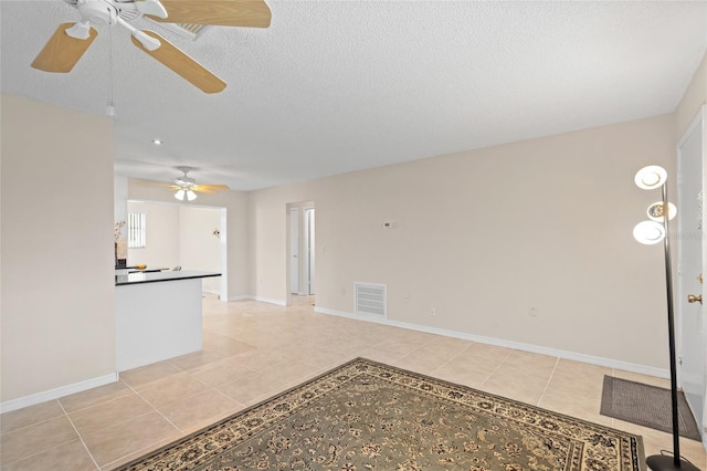 unfurnished living room with a textured ceiling and light tile patterned floors