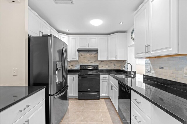 kitchen with white cabinets, light tile patterned floors, dark stone counters, black appliances, and sink