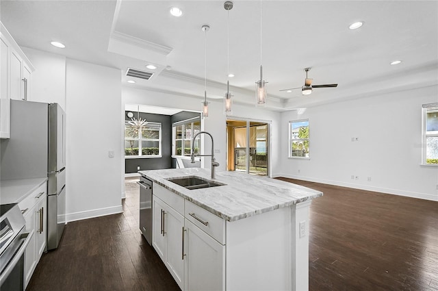 kitchen with a wealth of natural light, a center island with sink, sink, and appliances with stainless steel finishes