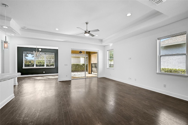 unfurnished living room featuring plenty of natural light and a tray ceiling