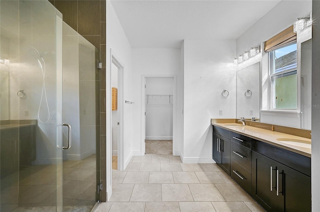 bathroom with a shower with door, vanity, and tile patterned flooring