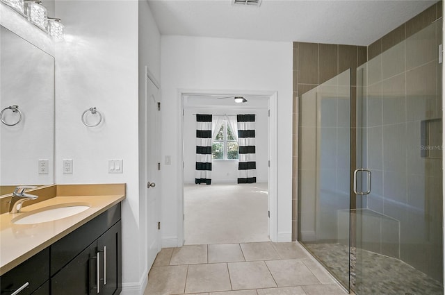 bathroom featuring an enclosed shower, vanity, a textured ceiling, and tile patterned floors