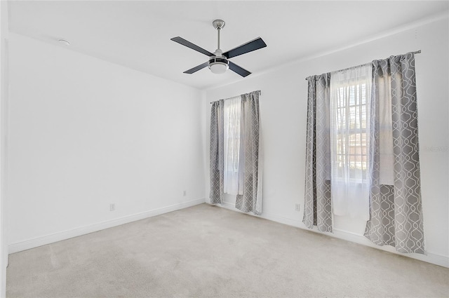 spare room featuring ceiling fan and light colored carpet