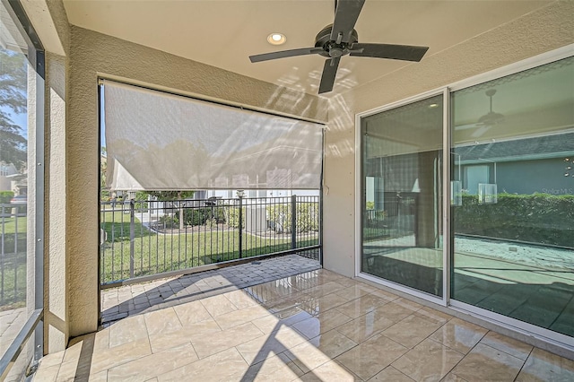 unfurnished sunroom featuring ceiling fan and a healthy amount of sunlight