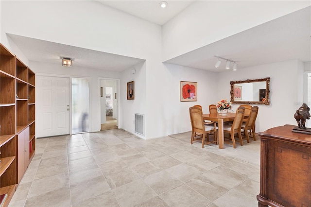 foyer featuring light tile patterned floors and track lighting