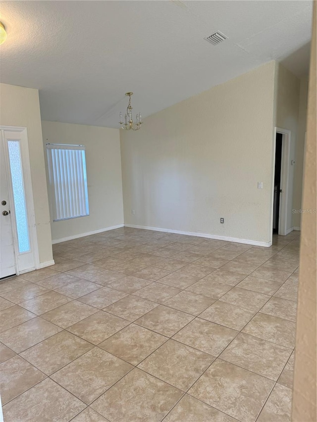 unfurnished room featuring light tile patterned flooring and a chandelier