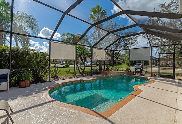 view of pool featuring glass enclosure and a patio