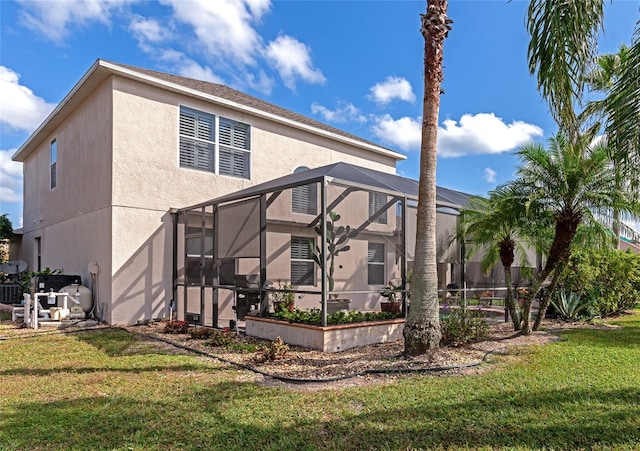 rear view of house with cooling unit, glass enclosure, and a yard