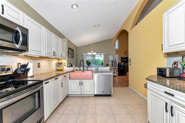 kitchen featuring white cabinets, kitchen peninsula, sink, pendant lighting, and appliances with stainless steel finishes