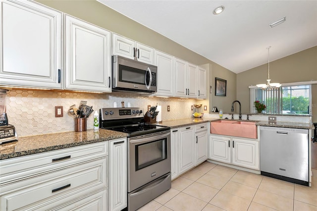 kitchen with white cabinets, appliances with stainless steel finishes, lofted ceiling, and sink