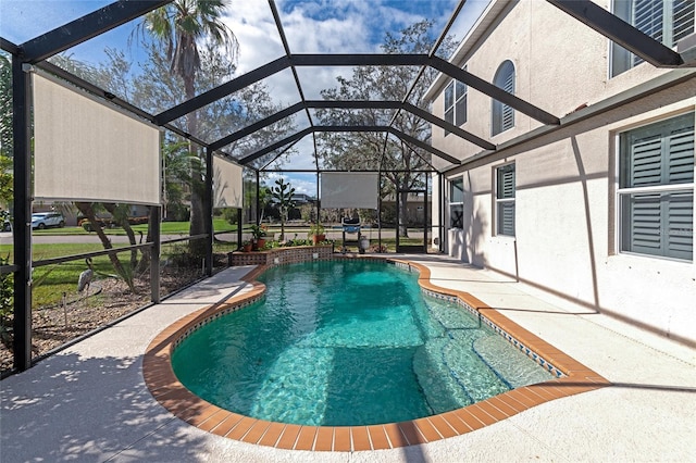 view of pool with glass enclosure and a patio area