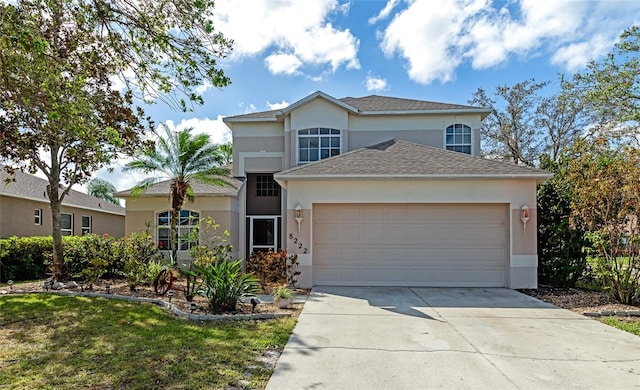 view of property featuring a garage and a front yard