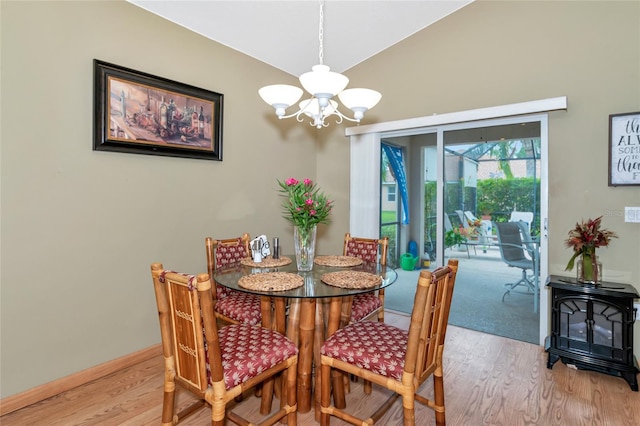 dining room featuring light hardwood / wood-style flooring, lofted ceiling, and an inviting chandelier