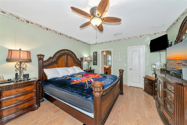 bedroom with ensuite bathroom, ceiling fan, and light wood-type flooring