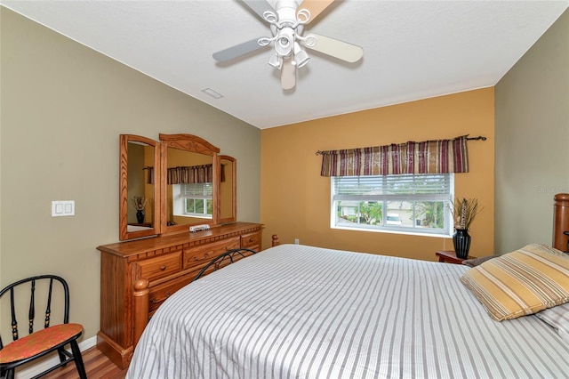 bedroom featuring hardwood / wood-style flooring, multiple windows, and ceiling fan