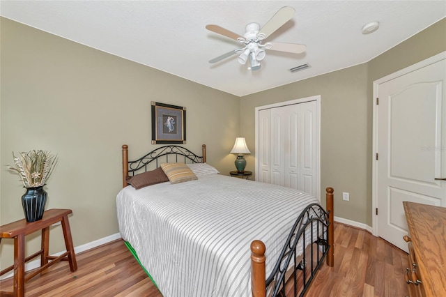 bedroom with hardwood / wood-style flooring, ceiling fan, and a closet