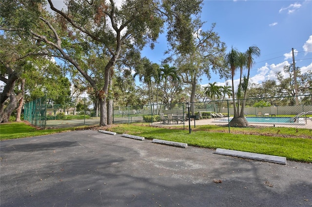 view of community featuring a swimming pool and a lawn