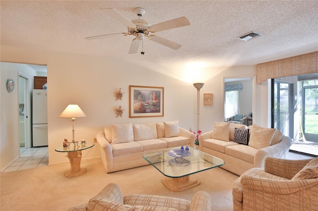 living room with ceiling fan, light colored carpet, a textured ceiling, and vaulted ceiling