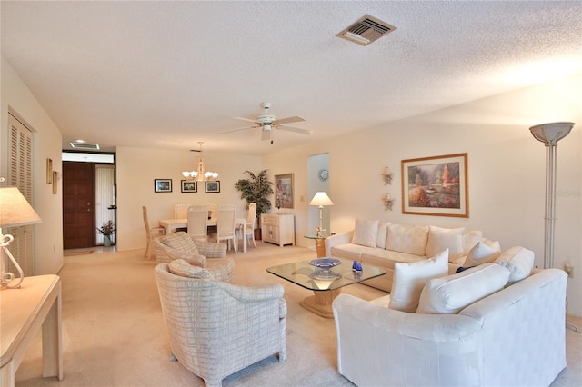 carpeted living room with ceiling fan with notable chandelier and a textured ceiling