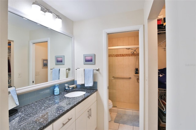 bathroom with toilet, vanity, an enclosed shower, and tile patterned floors