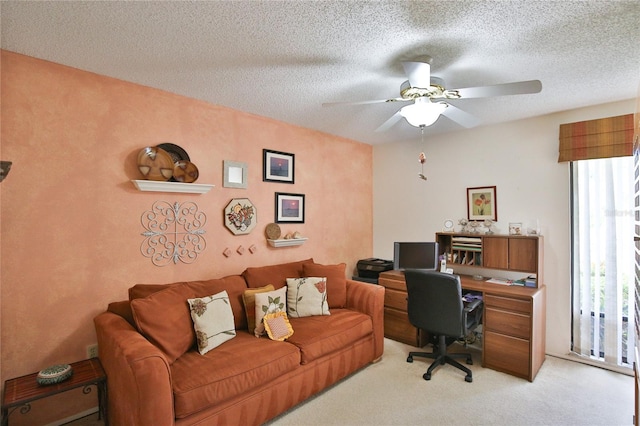 office space with a textured ceiling, light carpet, and ceiling fan