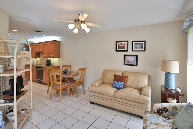 tiled living room with ceiling fan and sink