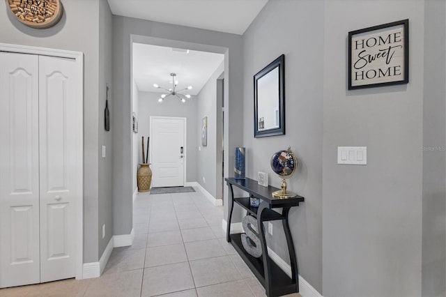 corridor featuring light tile patterned floors and an inviting chandelier