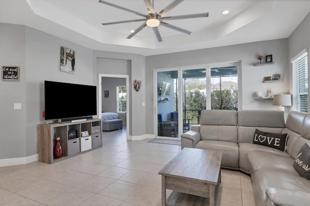 tiled living room featuring a raised ceiling and plenty of natural light