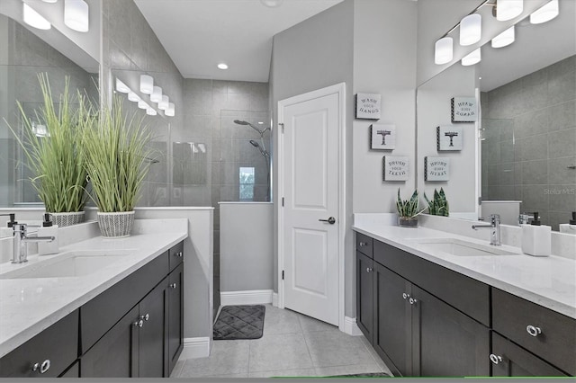 bathroom with tile patterned floors, vanity, and a tile shower