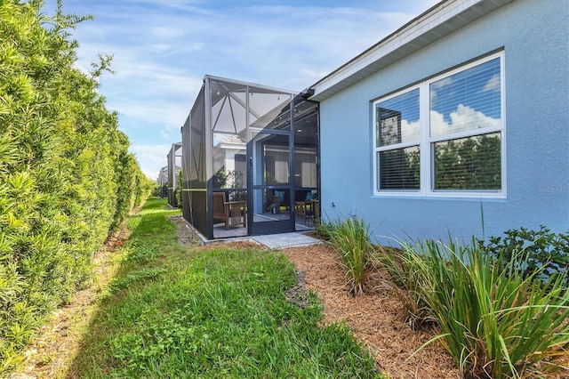 exterior space featuring a yard, a patio area, and a lanai