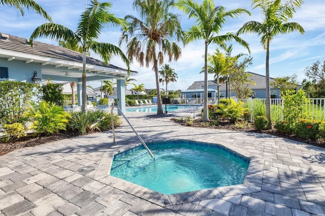 view of swimming pool with a hot tub