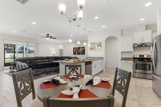 dining room with sink, ceiling fan with notable chandelier, and light tile patterned flooring