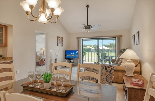 dining room with vaulted ceiling, ceiling fan with notable chandelier, and carpet floors