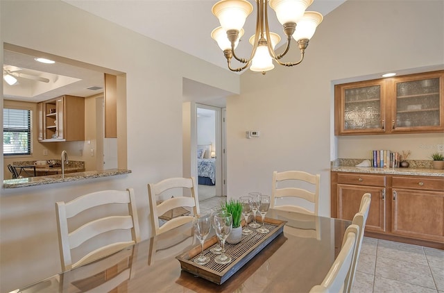 tiled dining space with ceiling fan with notable chandelier