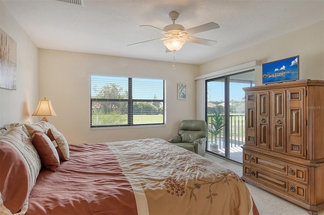 bedroom with a textured ceiling, light carpet, ceiling fan, and access to exterior