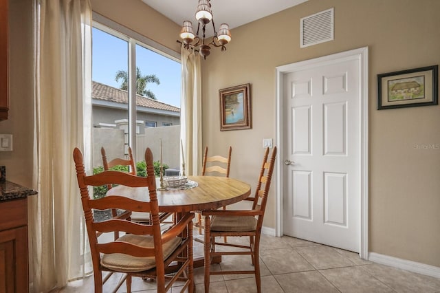 dining space featuring light tile patterned floors and an inviting chandelier