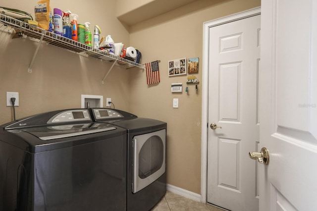 clothes washing area featuring independent washer and dryer and light tile patterned floors