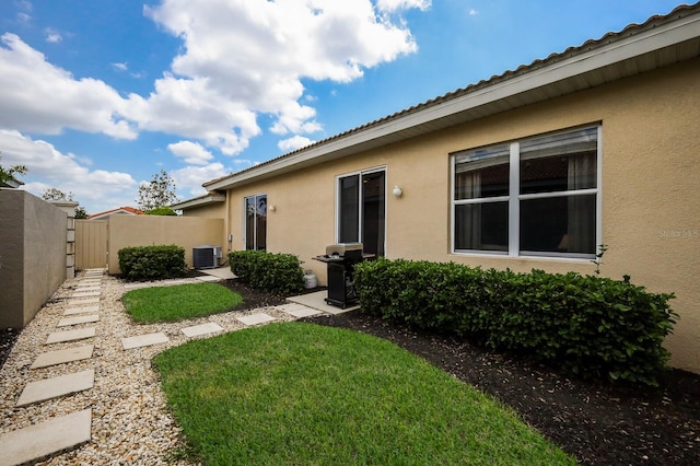 exterior space featuring a yard and cooling unit