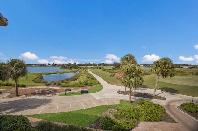 surrounding community featuring a lawn and a water view