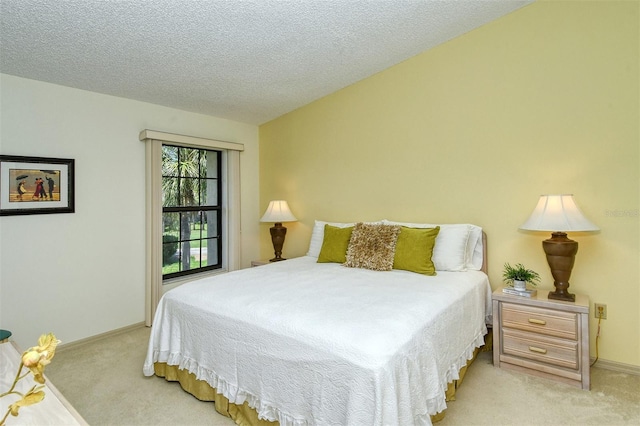 bedroom with light colored carpet and a textured ceiling