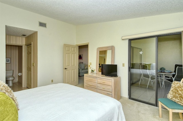 carpeted bedroom with a textured ceiling, a closet, and connected bathroom