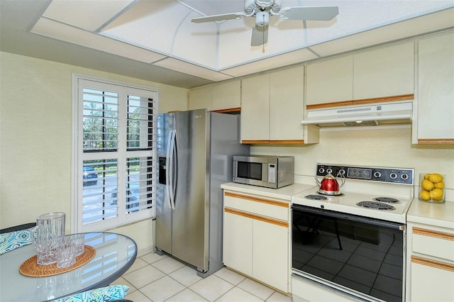 4416 Weybridge Unit 90, Sarasota, FL 34235 - kitchen featuring stainless steel appliances, under cabinet range hood, light countertops, light tile patterned floors, and a ceiling fan