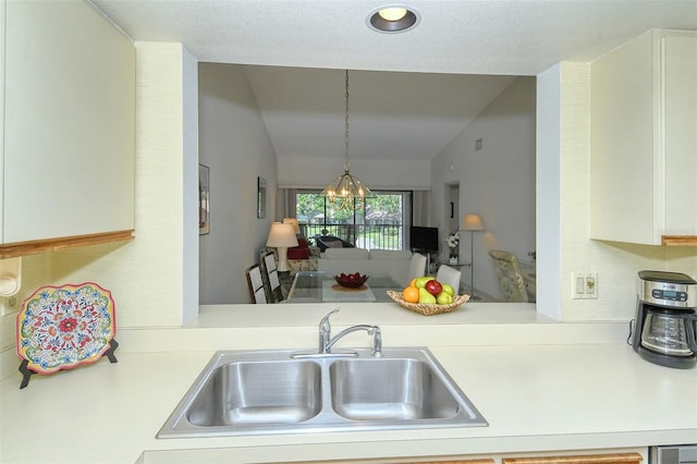 4416 Weybridge Unit 90, Sarasota, FL 34235 - kitchen featuring a sink, lofted ceiling, light countertops, and pendant lighting
