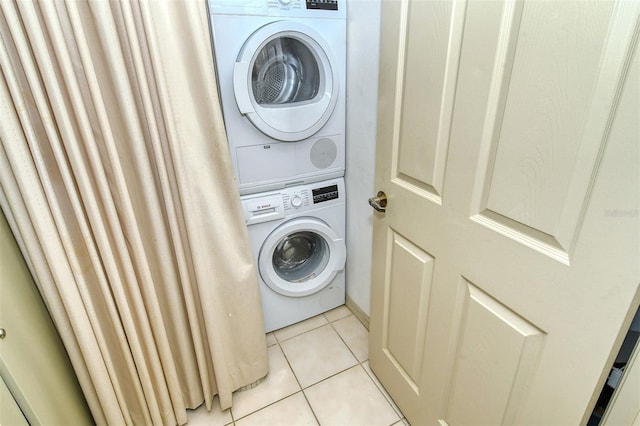 4416 Weybridge Unit 90, Sarasota, FL 34235 - laundry area featuring stacked washer and clothes dryer and light tile patterned floors