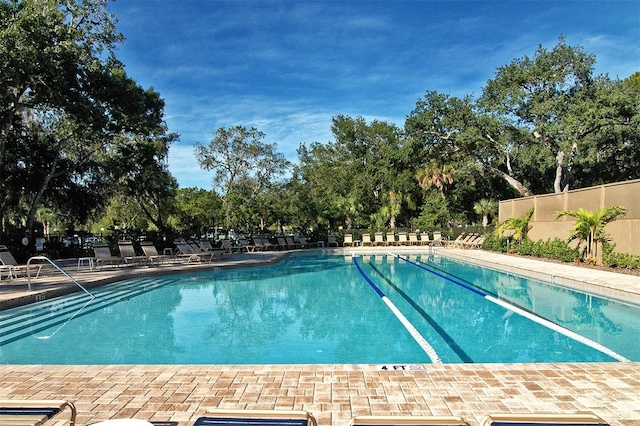 4416 Weybridge Unit 90, Sarasota, FL 34235 - community pool with fence, view of scattered trees, and a patio