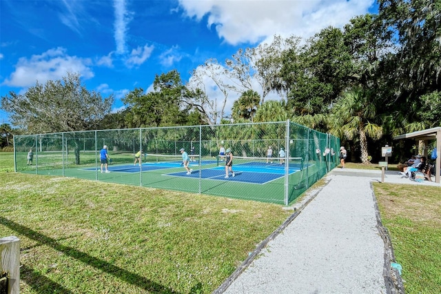 view of tennis court with a yard